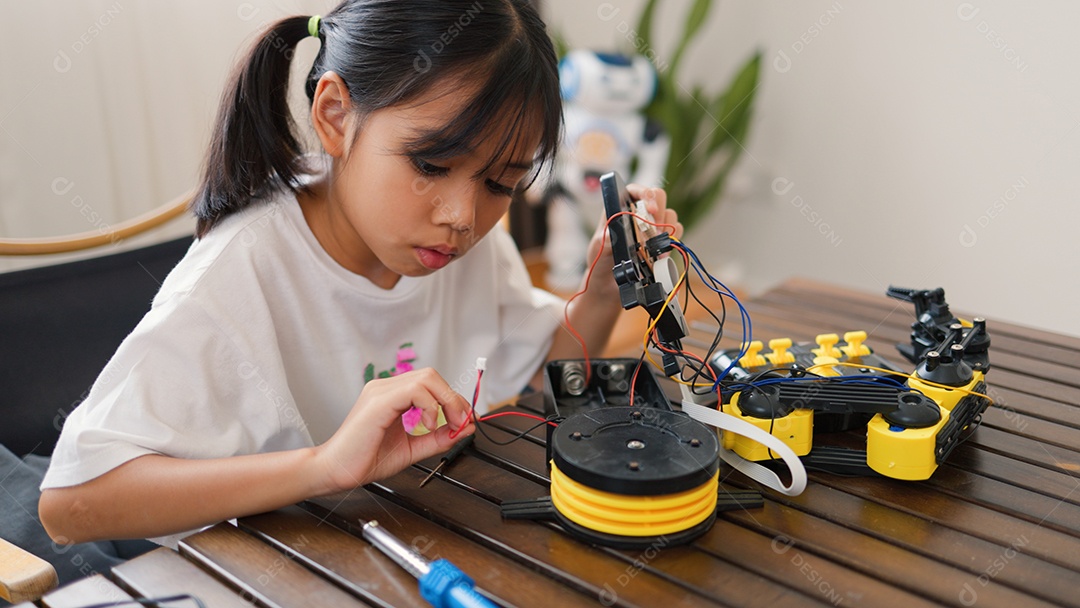 Garota asiática montando peças de robô em casa