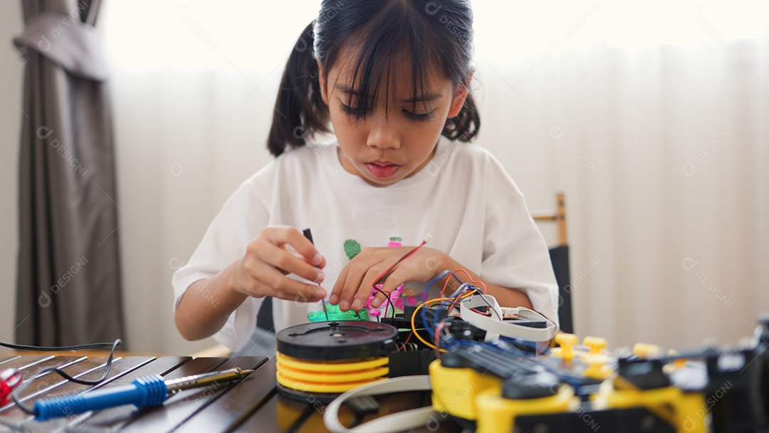 Garota asiática montando peças de robô em casa
