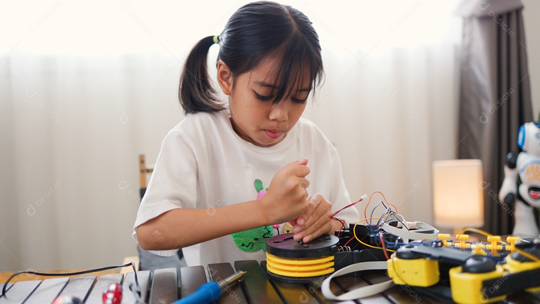 Garota asiática montando peças de robô em casa