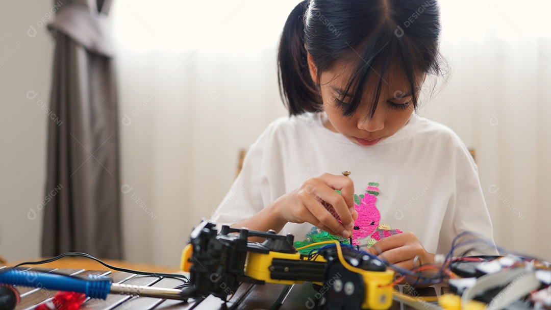 Garota asiática montando peças de robô em casa