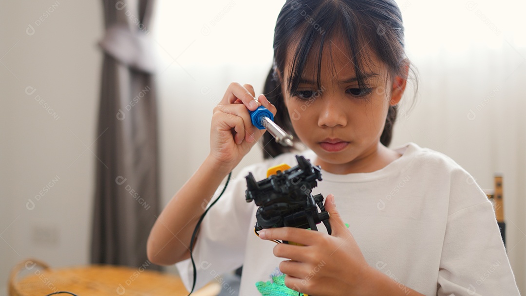 Garota asiática montando peças de robô em casa