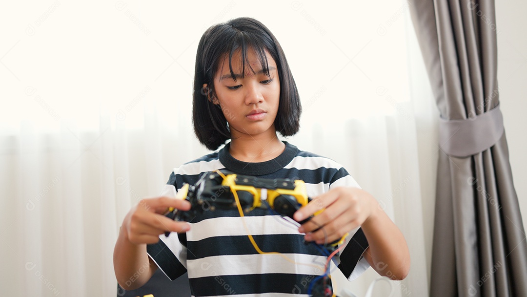 Garota asiática montando peças de robô em casa