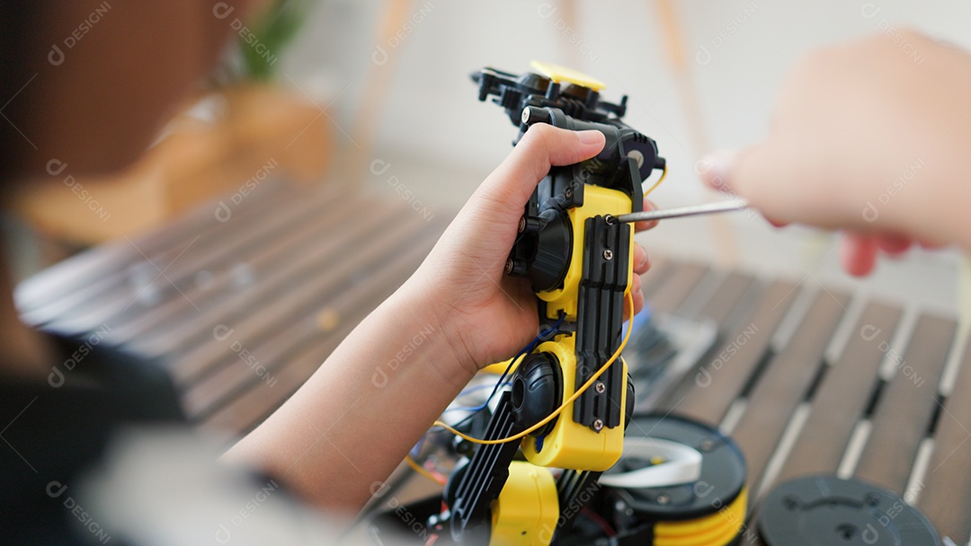 Garota asiática montando peças de robô em casa