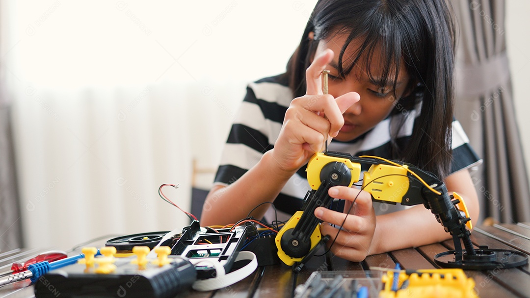 Garota asiática montando peças de robô em casa