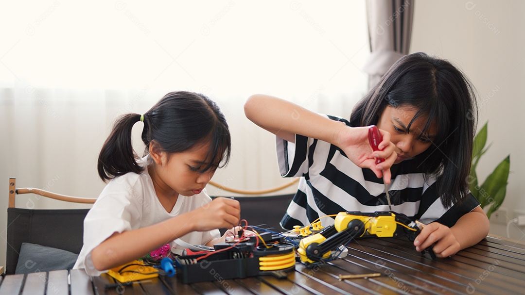 Garotas asiáticas montando peças de robô em casa