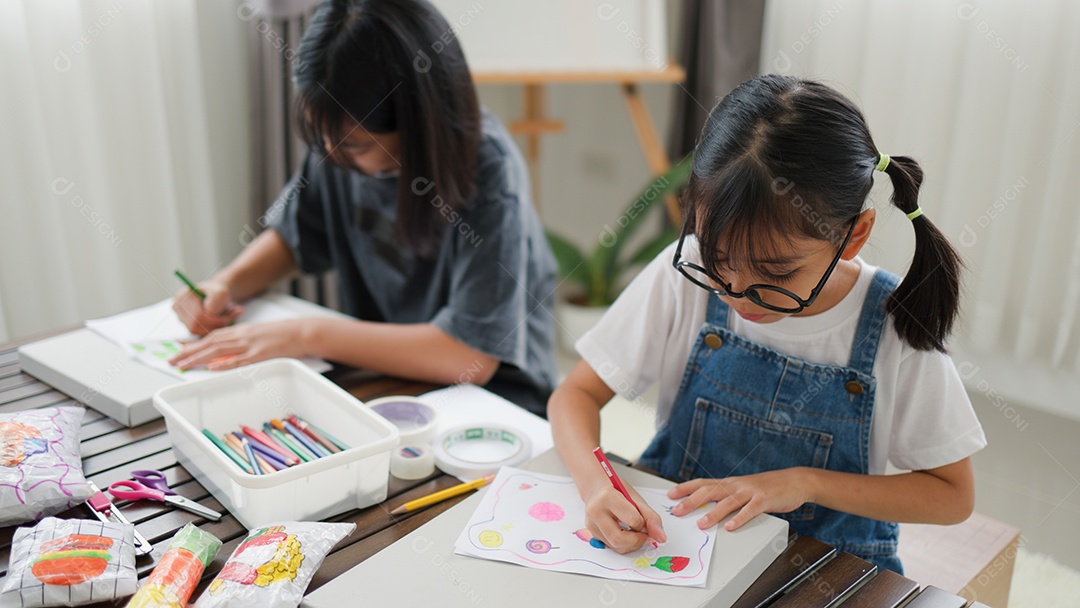 Duas meninas asiáticas estudando e desenhando em uma sala iluminada