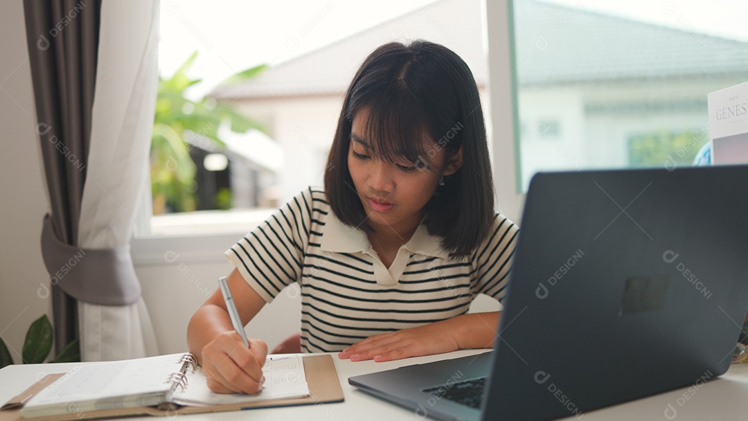 Menina asiática estudando em casa com foco