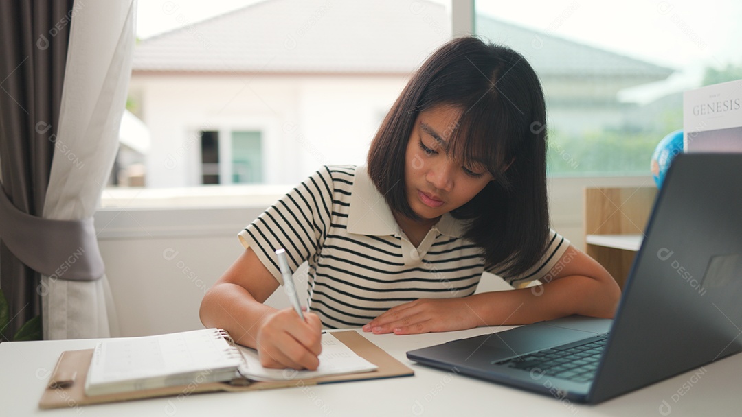 Menina asiática estudando em casa com foco