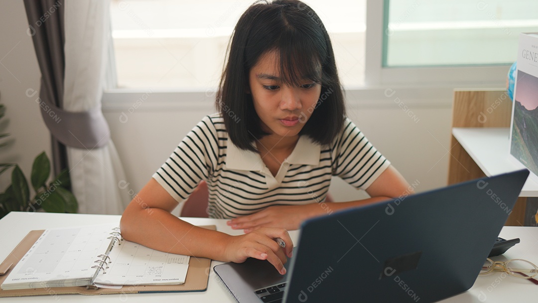 Menina asiática estudando em casa com foco