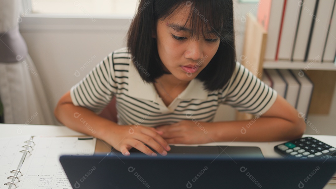 Menina asiática estudando em casa com foco