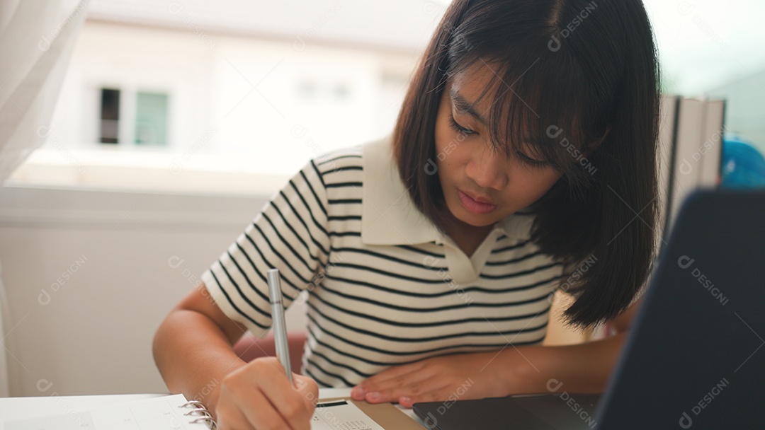 Menina asiática estudando em casa com foco