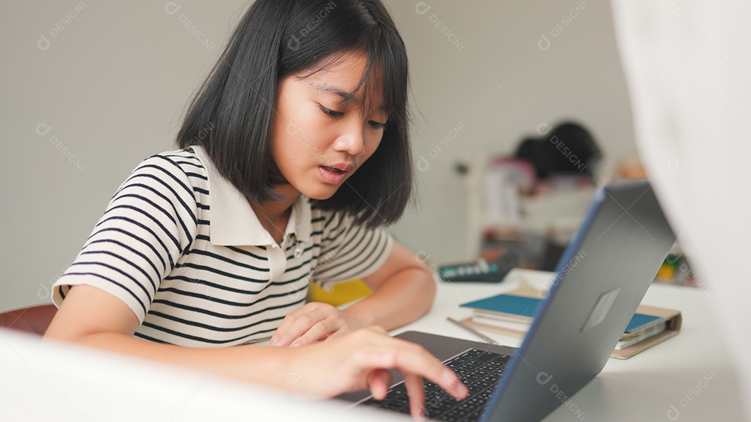 Menina asiática estudando em casa com foco