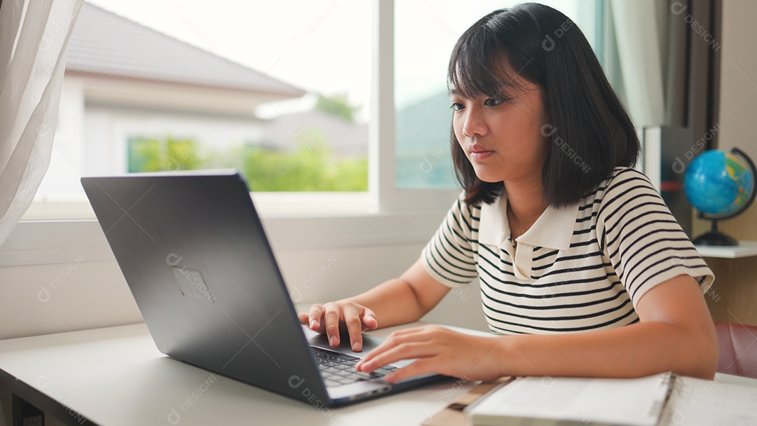 Menina asiática estudando em casa com foco