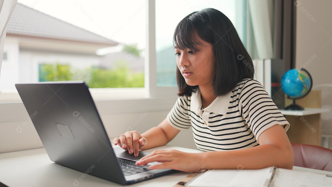 Menina asiática estudando em casa com foco