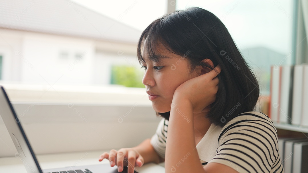 Menina asiática estudando em casa com foco