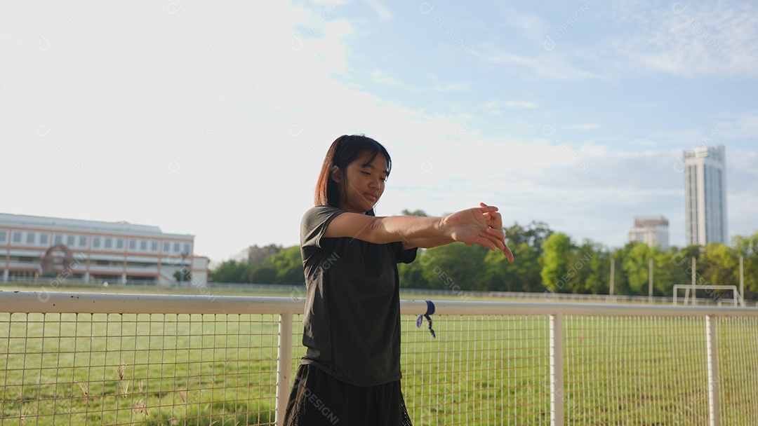 Adolescente asiática se alongando ao ar livre
