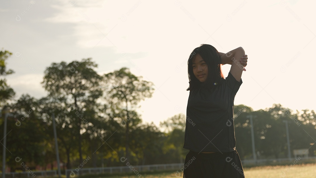 Adolescente asiática se alongando ao ar livre