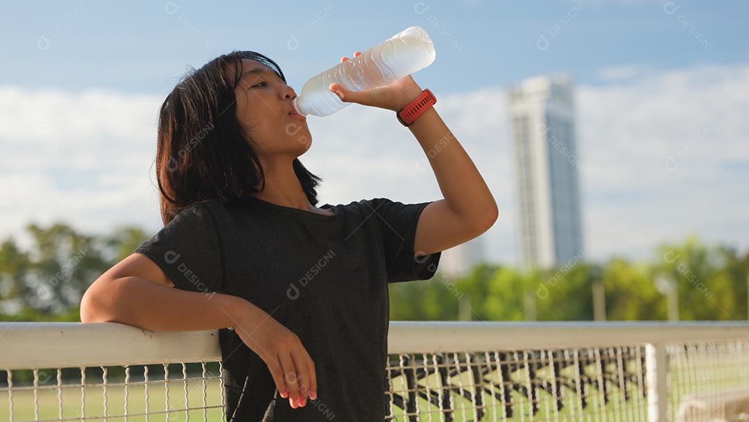 Adolescente asiática tomando água ao ar livre