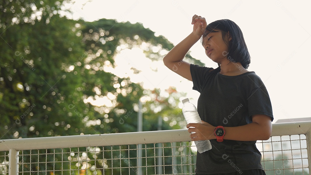 Adolescente asiática tomando água ao ar livre