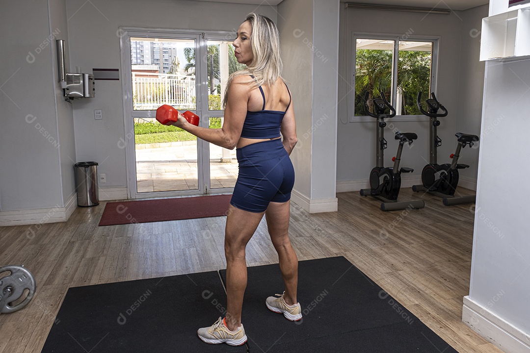 Mulher brasileira de 46 anos fazendo exercícios de costas na máquina de polia