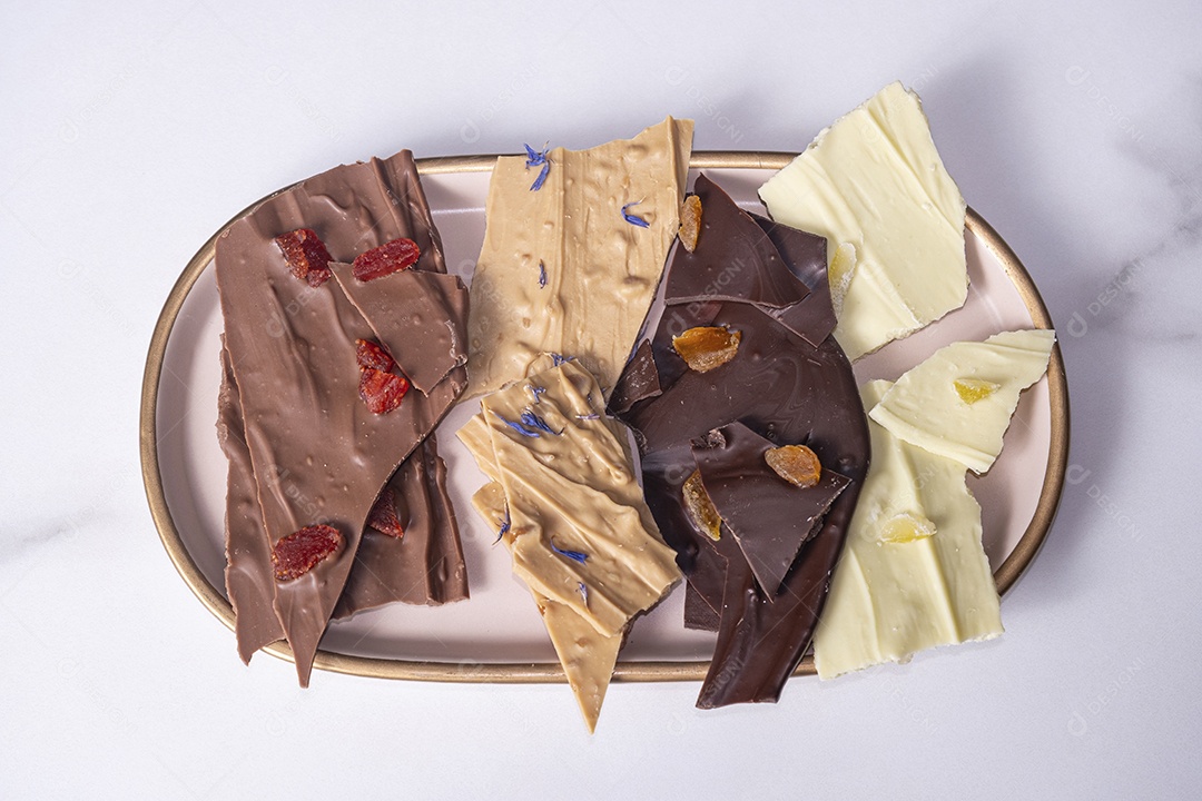 Uma caixa branca aberta com gotas de chocolate variadas