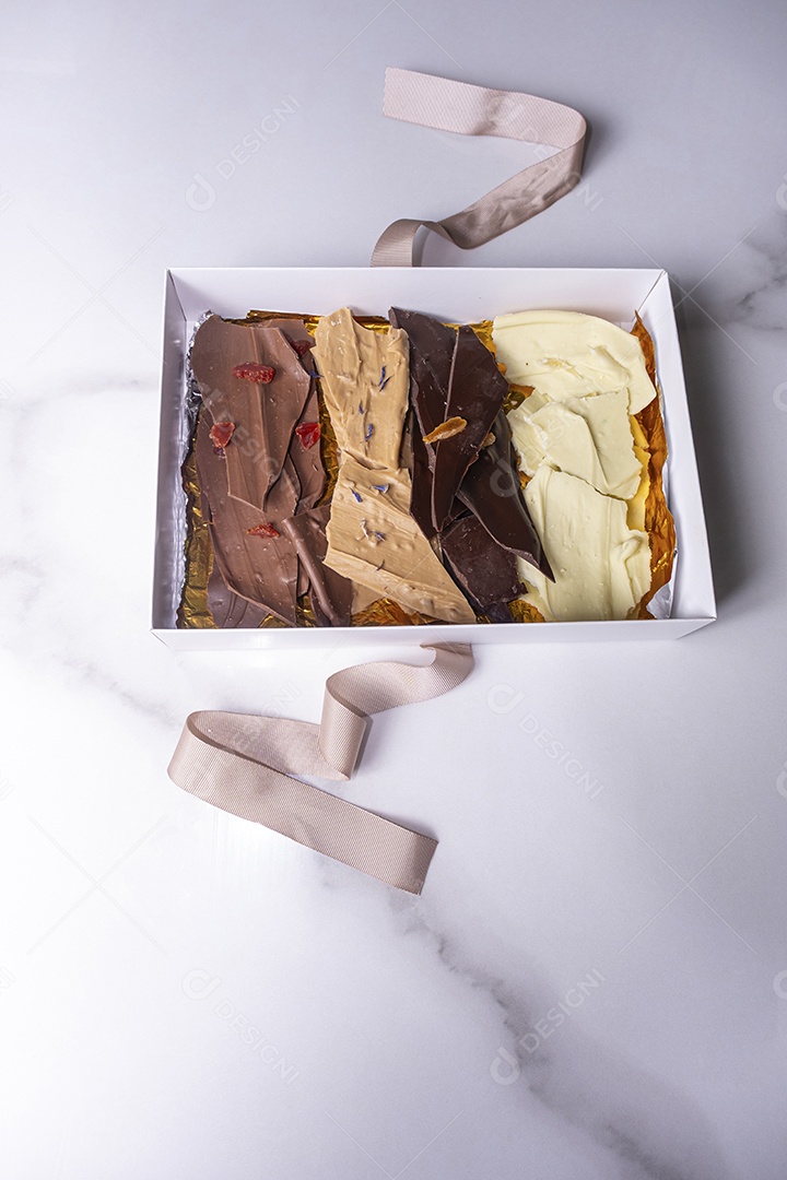 Gotas de chocolate de diferentes sabores dentro de uma caixa branca