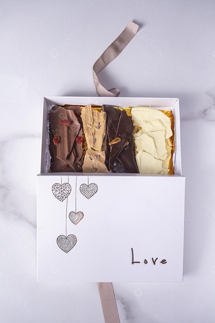 Gotas de chocolate de diferentes sabores dentro de uma caixa branca