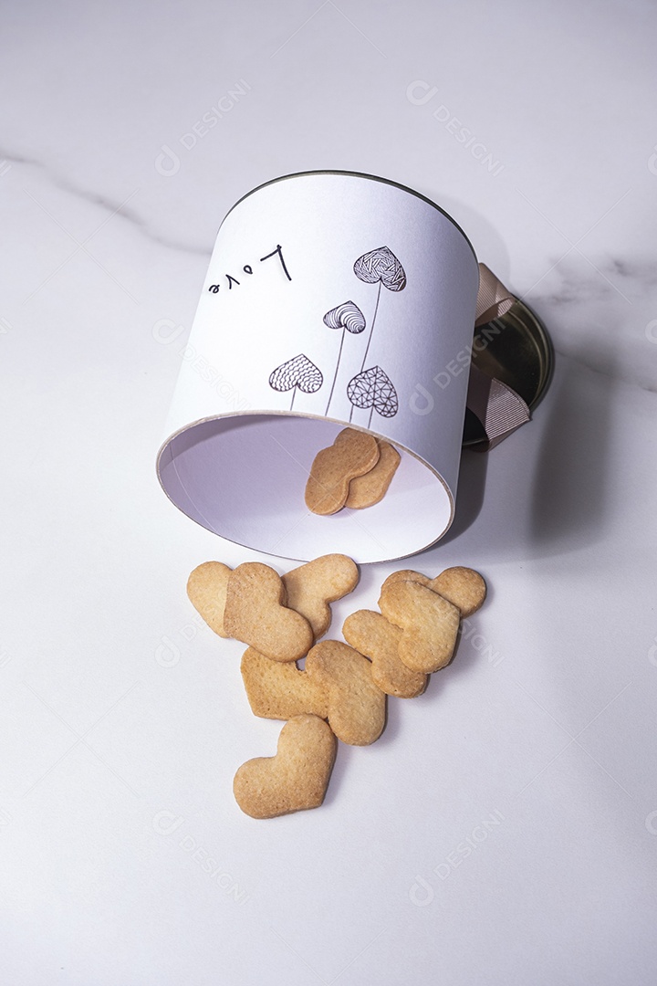 Biscoitos em formato de coração saindo de uma caixa branca circular