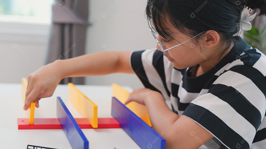 Menina asiática aprendendo STEM montando peças mecânicas com foco e determinação