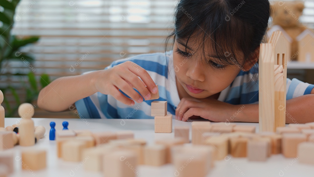 Jovem asiática focada em empilhar blocos de madeira