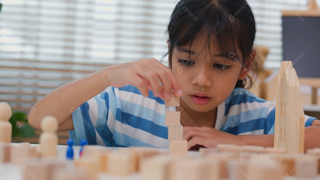Jovem asiática focada em empilhar blocos de madeira