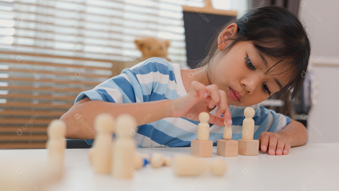 Jovem asiática focada em empilhar blocos de madeira