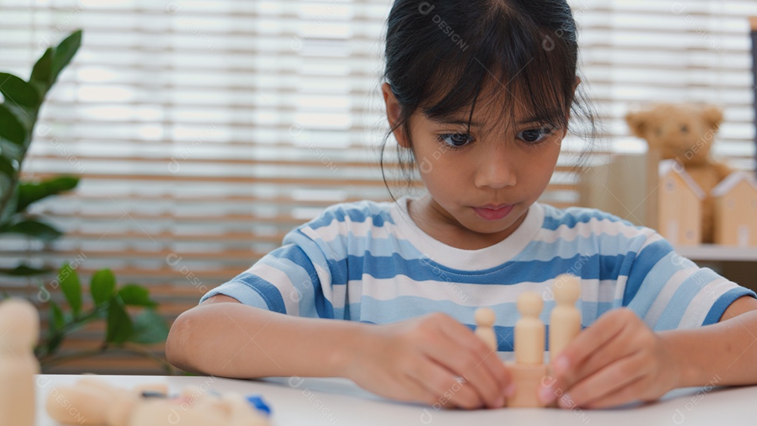 Jovem asiática focada em empilhar blocos de madeira