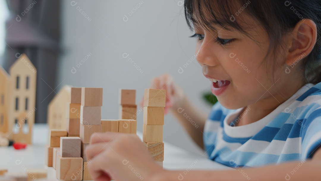 Jovem asiática focada em empilhar blocos de madeira