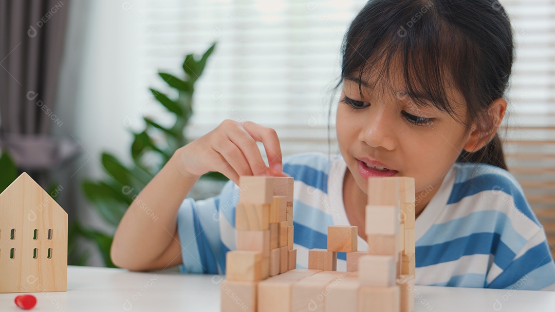 Jovem asiática focada em empilhar blocos de madeira