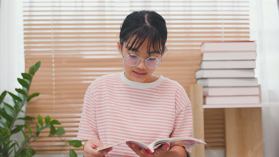 Adolescente lendo um livro em casa com concentração