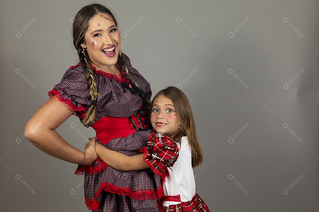Mãe ao lado de sua filha usando roupas típicas festa junina sobre fundo isolado