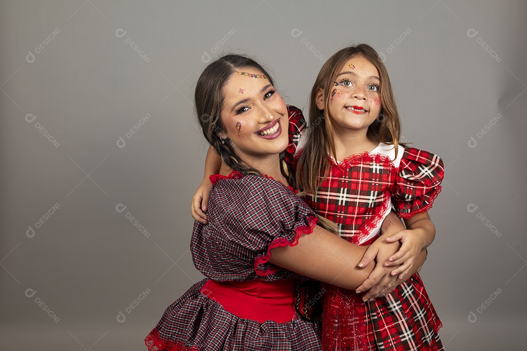 Mãe ao lado de sua filha usando roupas típicas festa junina sobre fundo isolado