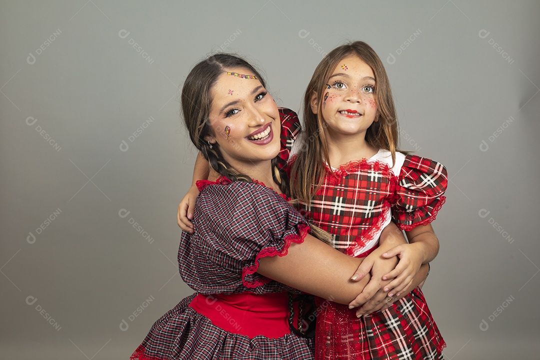 Mãe ao lado de sua filha usando roupas típicas festa junina sobre fundo isolado