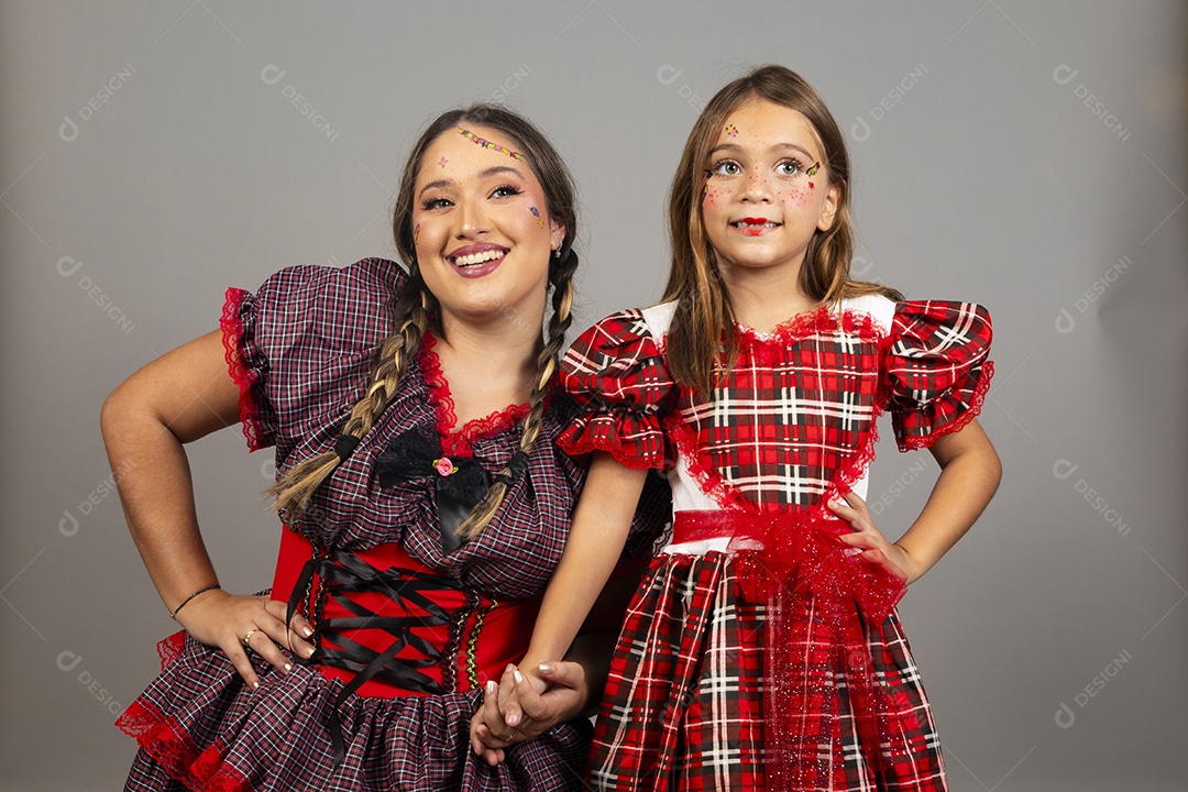 Mãe ao lado de sua filha usando roupas típicas festa junina sobre fundo isolado