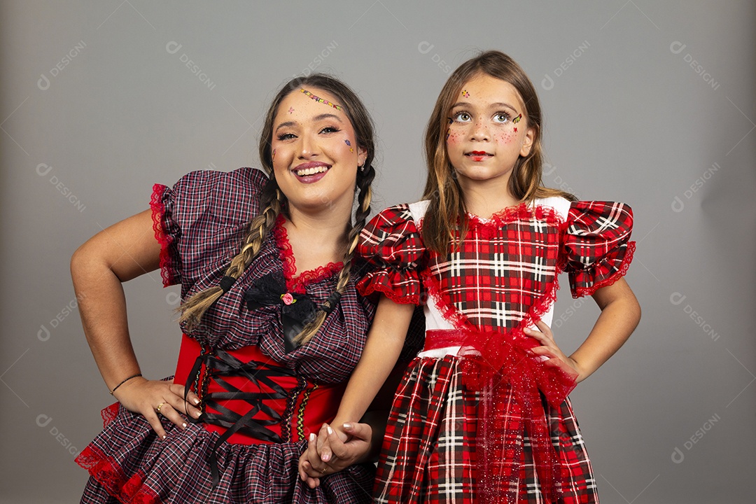 Mãe ao lado de sua filha usando roupas típicas festa junina sobre fundo isolado