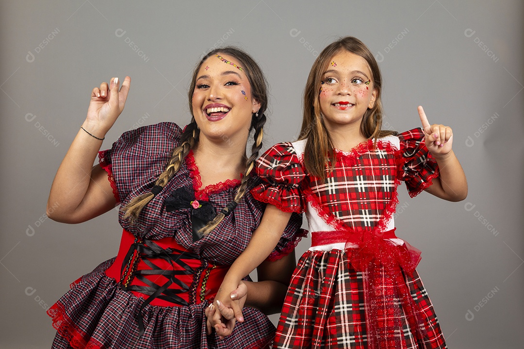 Mãe ao lado de sua filha usando roupas típicas festa junina sobre fundo isolado