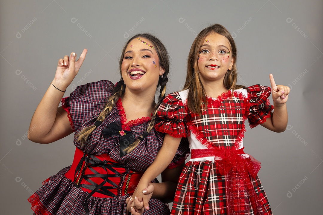 Mãe ao lado de sua filha usando roupas típicas festa junina sobre fundo isolado