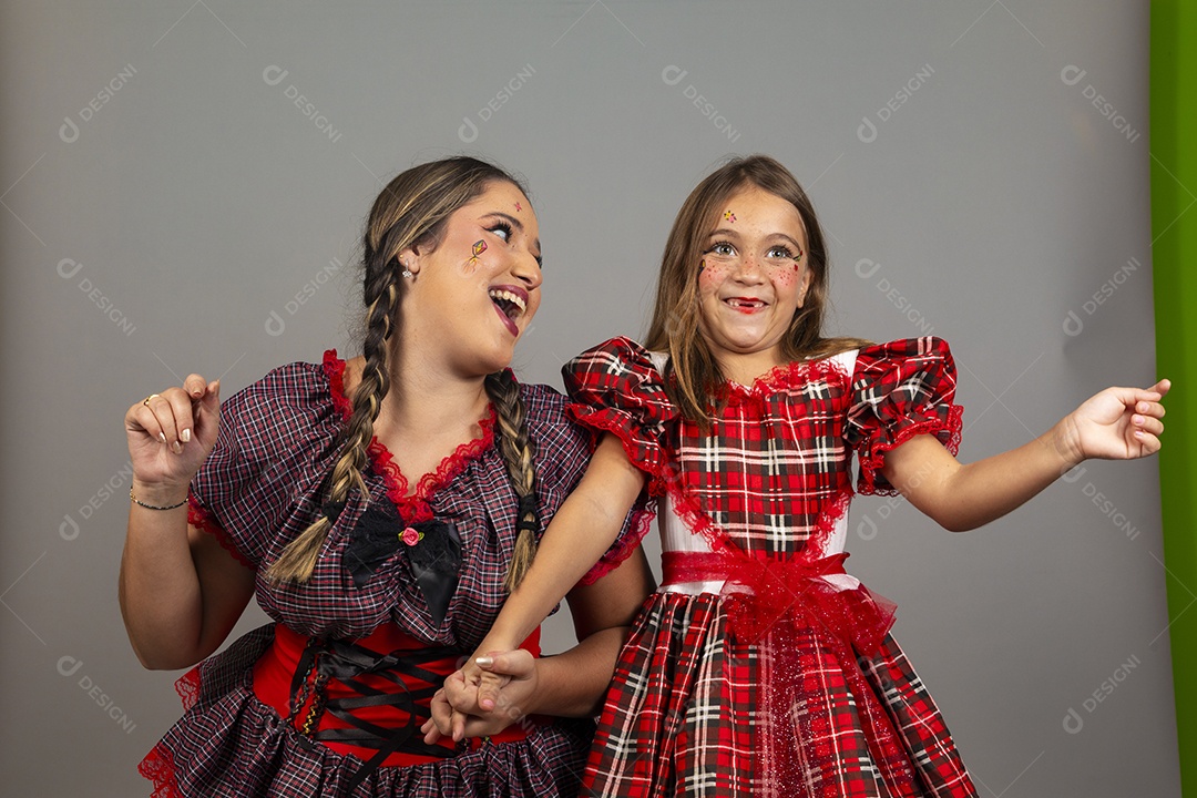 Mãe ao lado de sua filha usando roupas típicas festa junina sobre fundo isolado