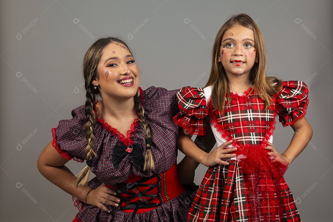 Mãe ao lado de sua filha usando roupas típicas festa junina sobre fundo isolado