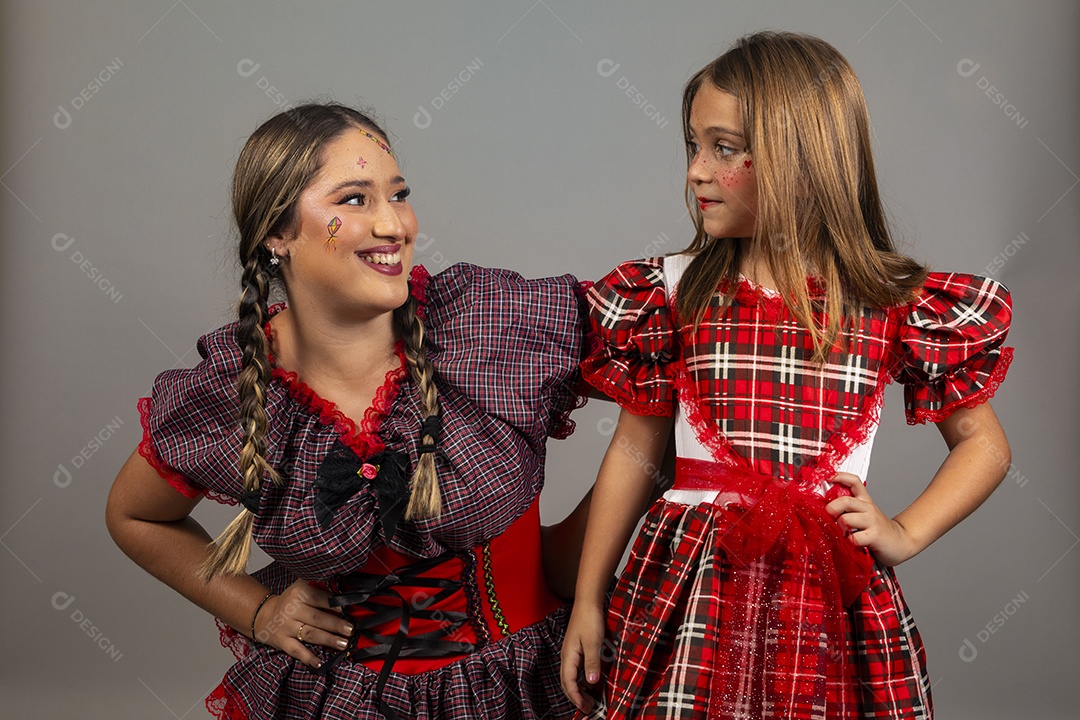Mãe ao lado de sua filha usando roupas típicas festa junina sobre fundo isolado