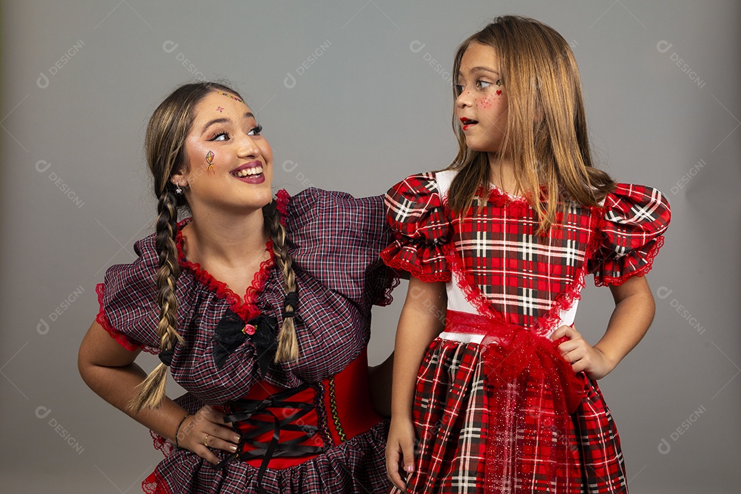 Mãe ao lado de sua filha usando roupas típicas festa junina sobre fundo isolado