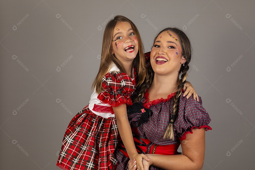 Mãe ao lado de sua filha usando roupas típicas festa junina sobre fundo isolado