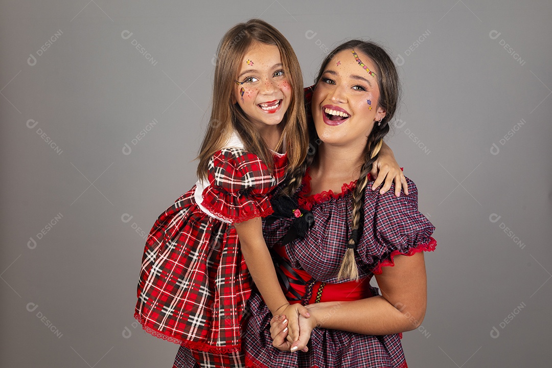 Mãe ao lado de sua filha usando roupas típicas festa junina sobre fundo isolado