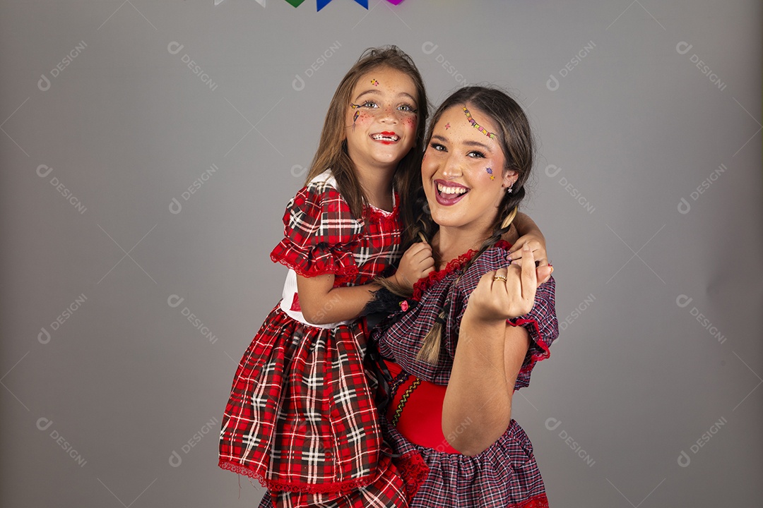 Mãe ao lado de sua filha usando roupas típicas festa junina sobre fundo isolado